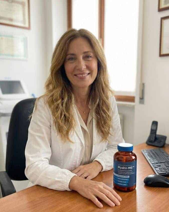 Donna sorridente con integratore di collagene marino Hydro-M5 in ufficio.