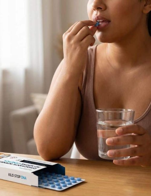 Donna che prende un integratore con acqua, vicino a un blister di Kilo Stop DNA.